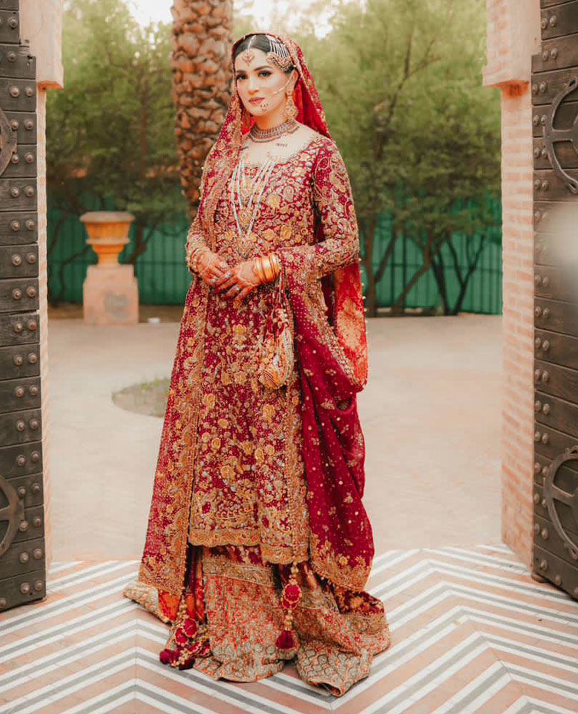 A BREATHTAKING TRADITIONAL BRIDE ON HER WEDDING DAY IN A CLASSIC RED AND GOLD FARAH TALIB AZIZ SIGNATURE BRIDAL