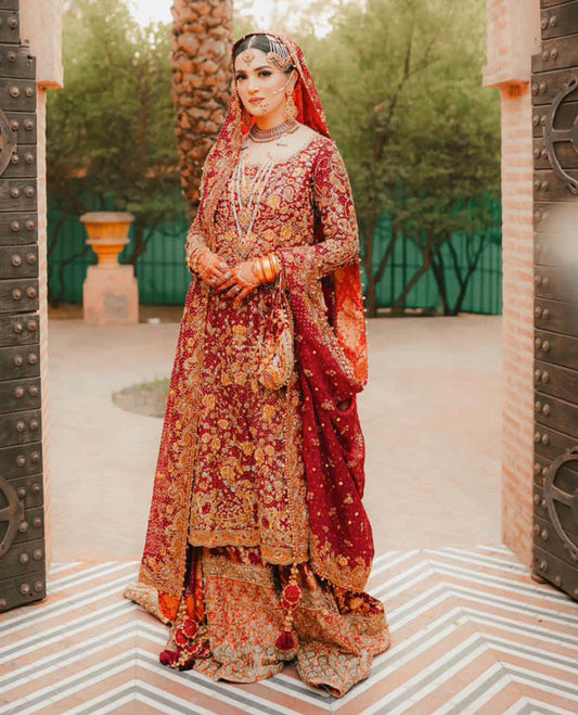 A BREATHTAKING TRADITIONAL BRIDE ON HER WEDDING DAY IN A CLASSIC RED AND GOLD FARAH TALIB AZIZ SIGNATURE BRIDAL