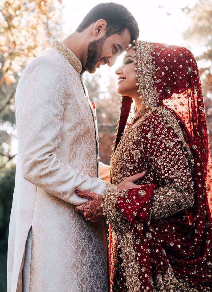 Syeda, a breathtaking traditional bride on her wedding day in a classic red and gold Farah Talib Aziz signature bridal