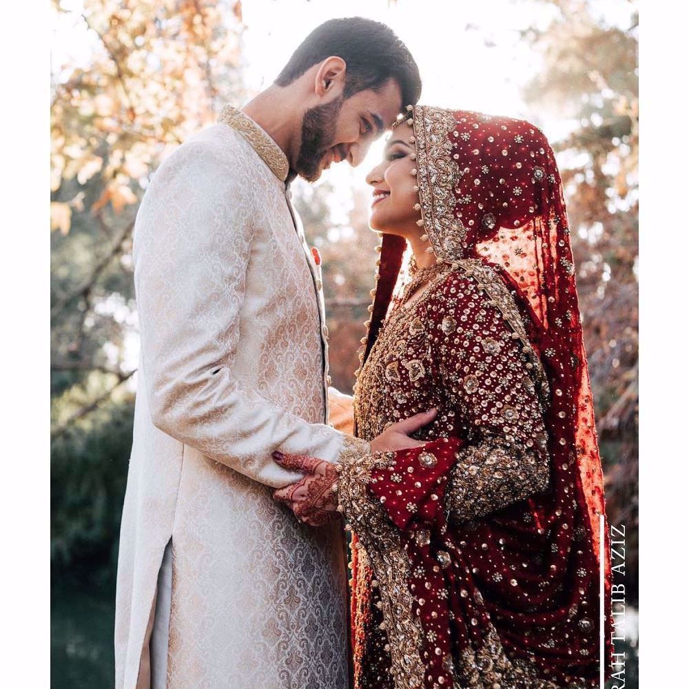 Syeda, a breathtaking traditional bride on her wedding day in a classic red and gold Farah Talib Aziz signature bridal