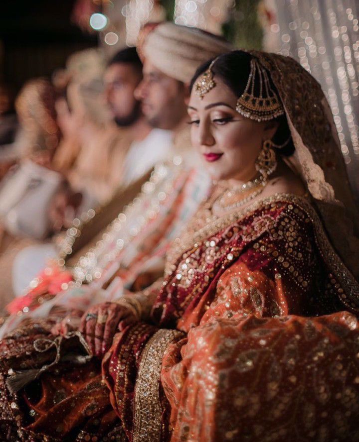 Sundas Malik look ravishing in a regal scarlet and gold ensemble, accentuated with a burnt orange and scarlet chunri chaddar